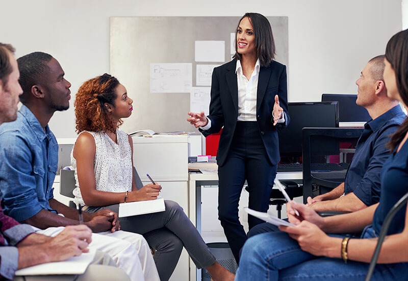 An MBA grad discusses the benefits of an MBA with a group of students.