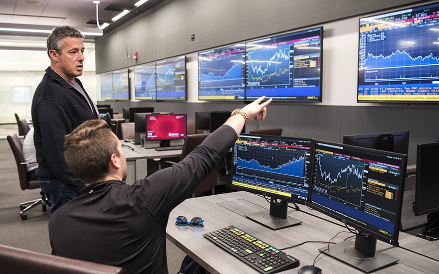 Alumnus Ricky Sandler talks with a student in the new Finance and Analytics Lab at WSB