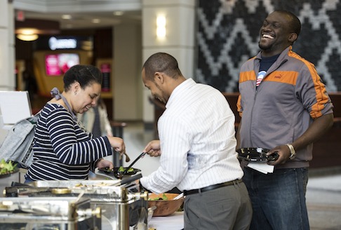 Ashligh Coaxum (MBA '16), left, and Justin Johnson (MBA '16), middle, grabs a bite to eat with Tosan Olley (MBA '15) and a hardy laugh before heading into a Lunch and Learn event on Wednesday, April 29, 2015.