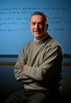 Barry Gerhart stands against a whiteboard with research
