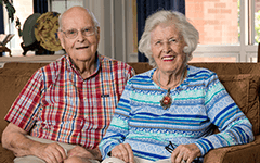 Jack and Marian Bolz sit side by side on a couch