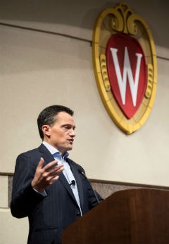 Alumnus John Peirson speaks under the UW crest