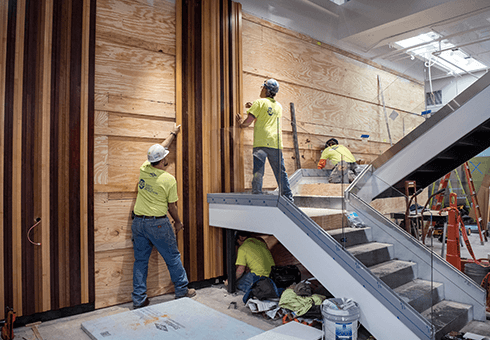 Construction workers install wood paneling in WSB's new Learning Commons.