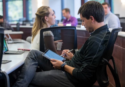 Evening MBA students mingle before class with Surface tablets