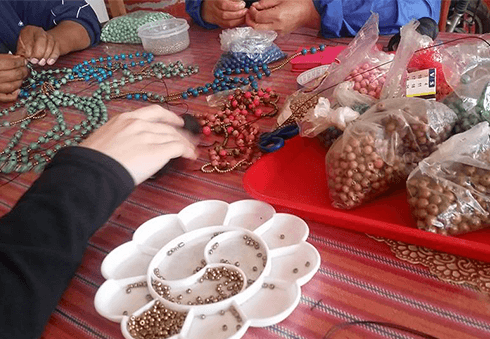 A photo of hands hard at work making jewelry