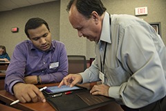 Enrique Rueda (right), multimedia coordinator at the Wisconsin School of Business, helps first-year Wisconsin Executive MBA student Joseph Koruth set up his new iPad Pro during the first day of class.