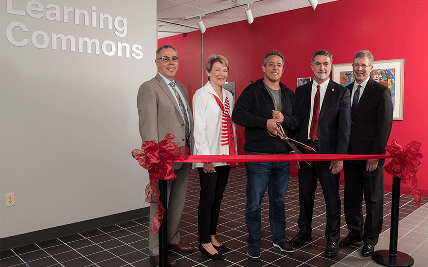 A group of University leaders pose for a ribbon cutting of WSB's Learning Commons.