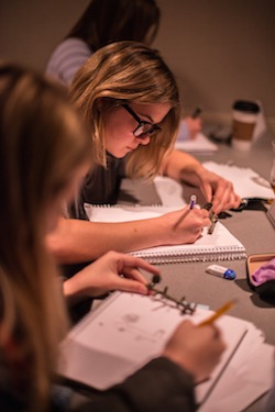 Students writing at desks