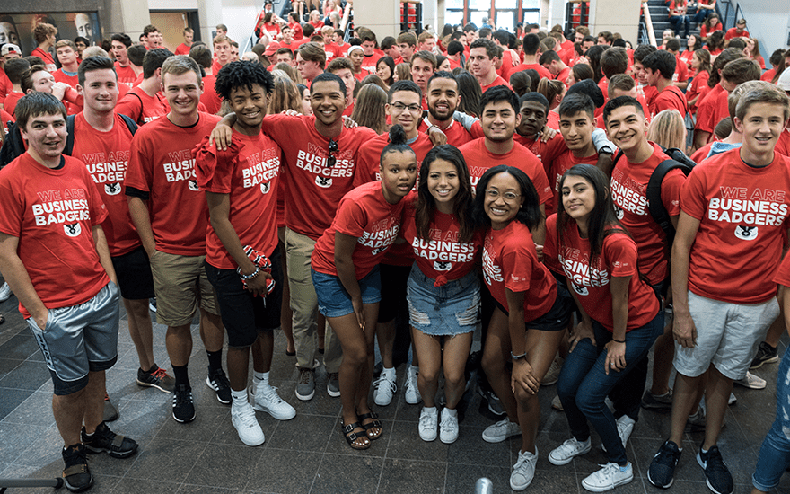 BBA students cluster for a picture during their BBA induction wearing red shirts