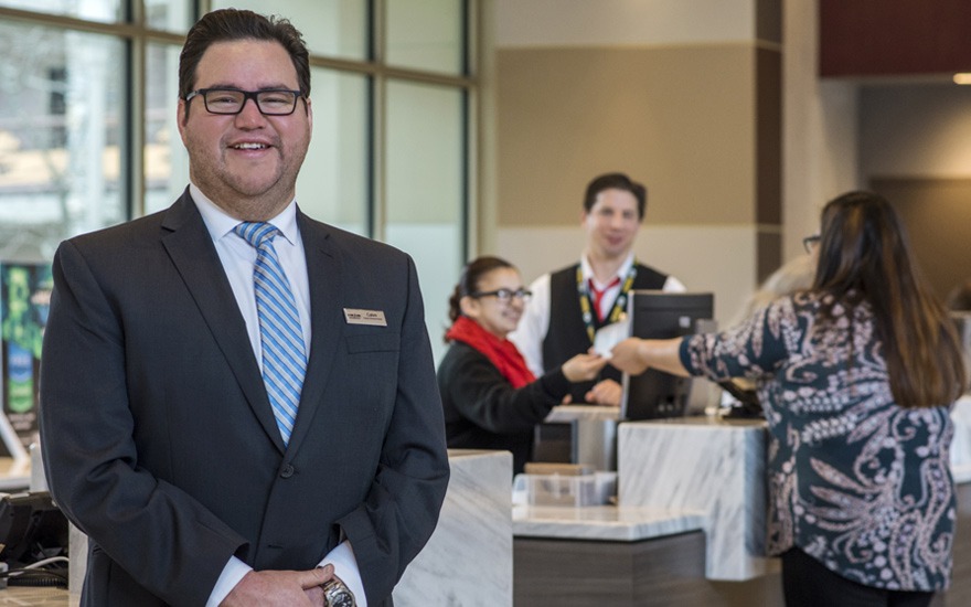 Man poses in front of two coworkers