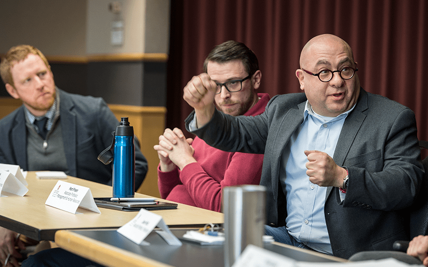 Hart Posen makes a point while seated on a faculty panel