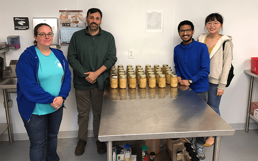 Porchlight's Melissa Guth and Daniel Barners stand with students in the organization's east side kitchen