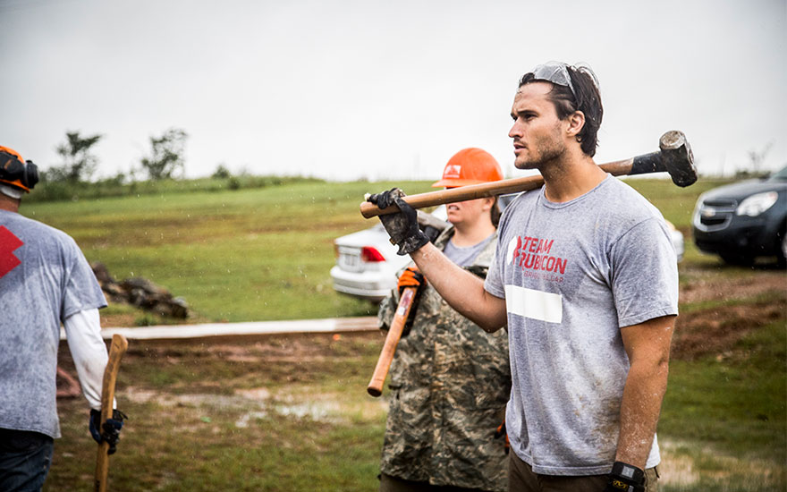 Jake Wood carrying a sledgehammer to work on disaster relief in the Bahamas