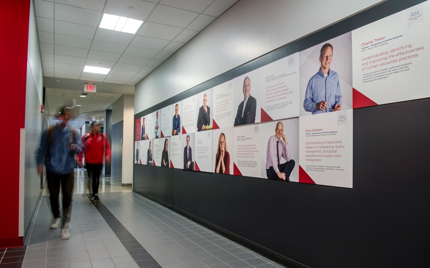 Students walking by posters of the School's Gaumnitz Research Award Winners