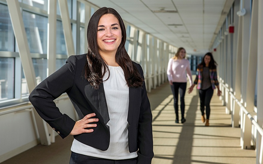 Female student standing in a long hallway