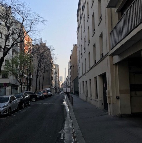 View down city street with Eiffel Tower in distance