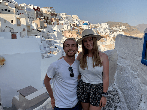 friends standing in front of the city of Santorini, Greece