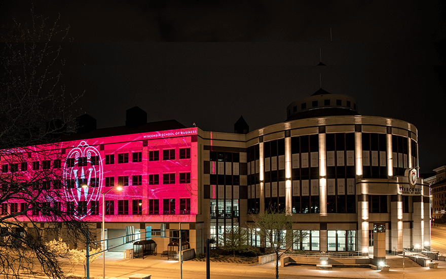 The exterior of Grainger Hall is illuminated with congratulatory messages for graduates