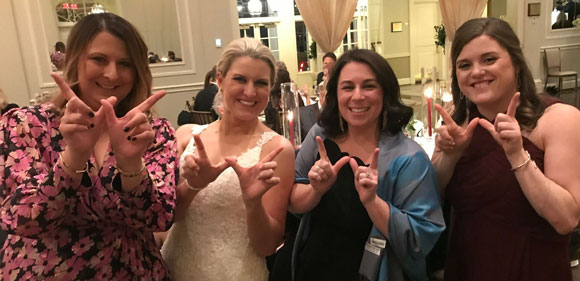 Kendra Armstrong and friends showing the W hand gesture at her wedding