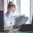 woman wearing face mask and working from home