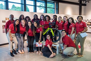Students posing for a group photo with a Trek bicycle.