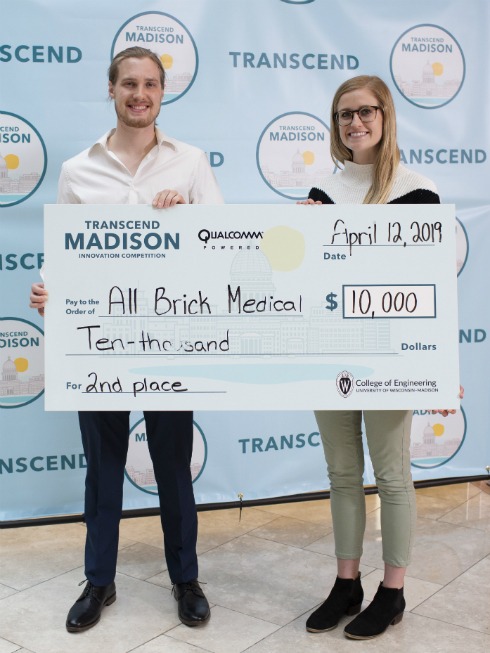 WAVE class alumni holding a giant check