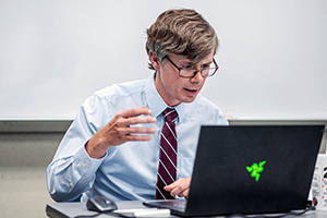 Lecturer Matt Griffith sits in front of his computer to teach an online course