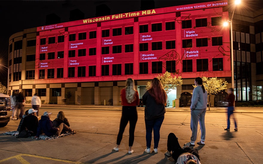 Graduating students have their names projected on Grainger Hall