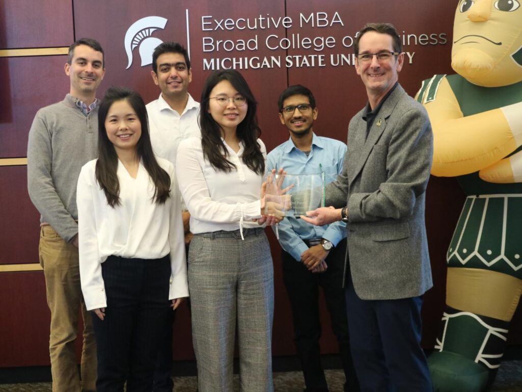 MBA students with trophy
