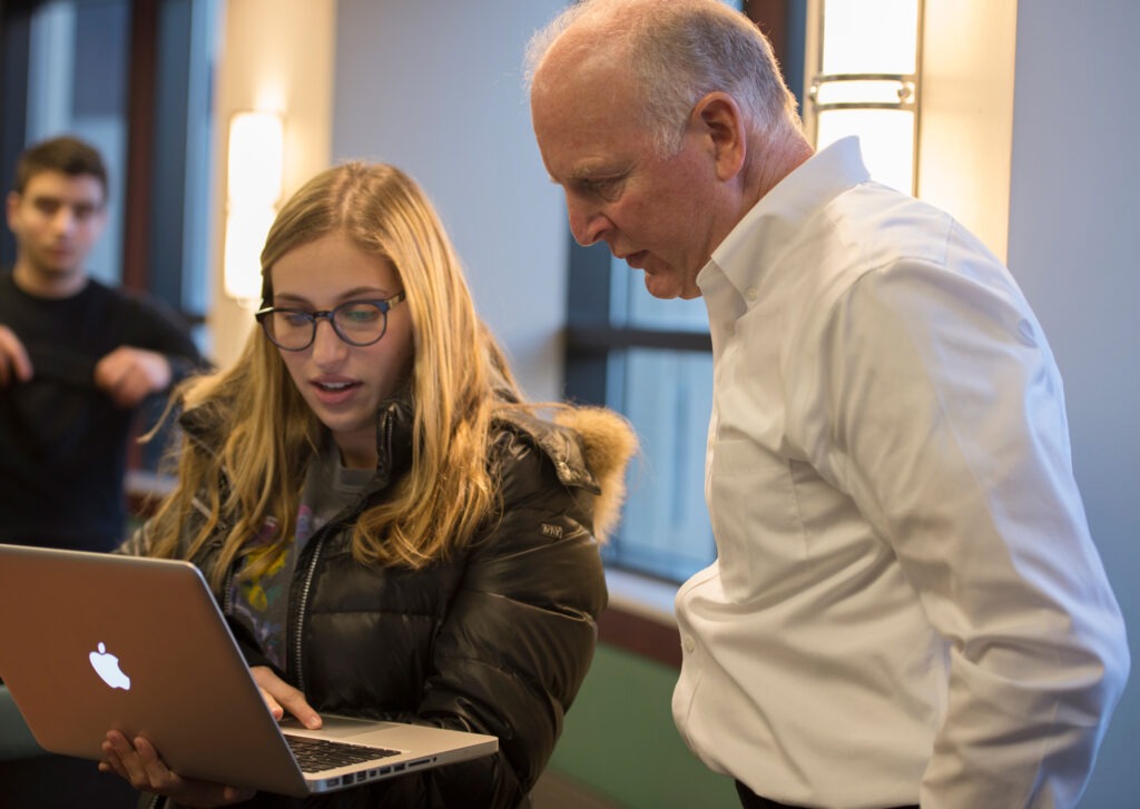 An instructor and a student looking at a laptop