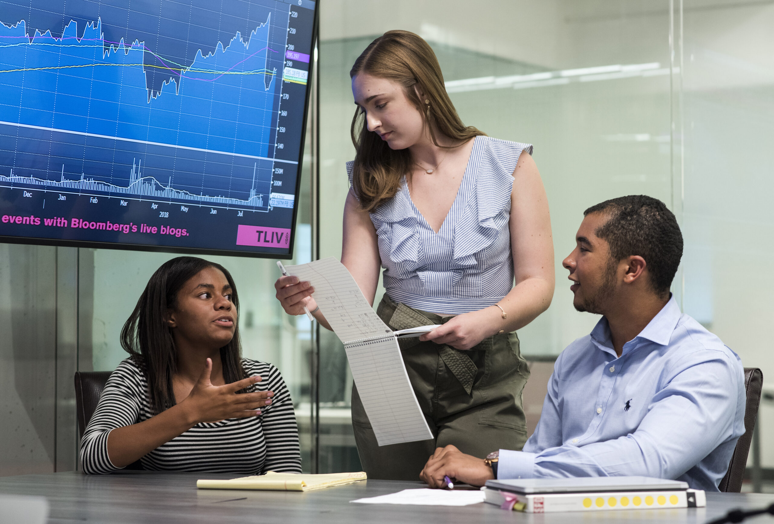 A man and two women working at a table on a project