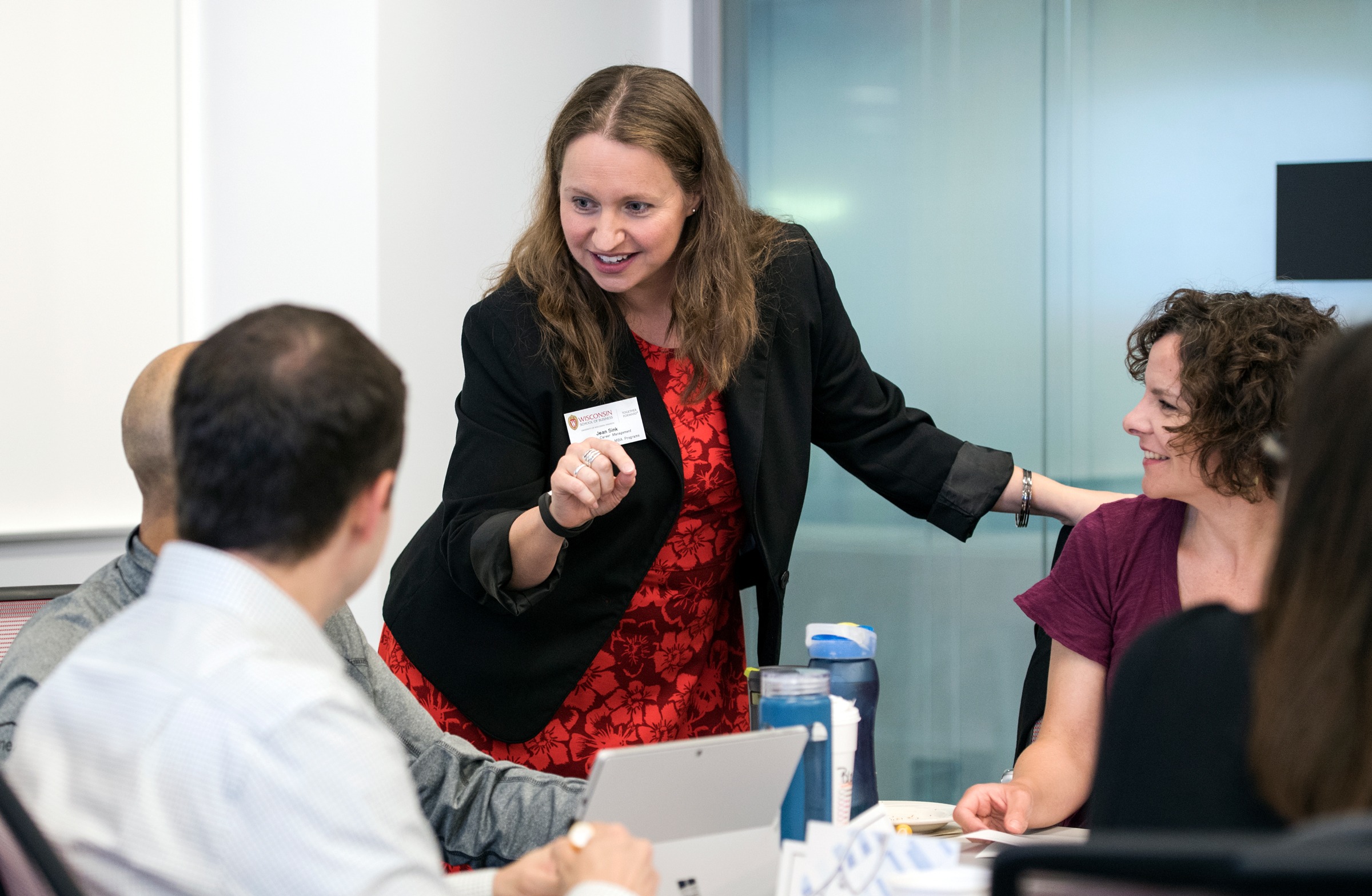 A woman talking to a group of people at a table