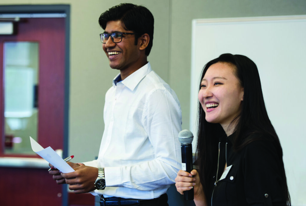 A man holding paper and a woman holding a microphone