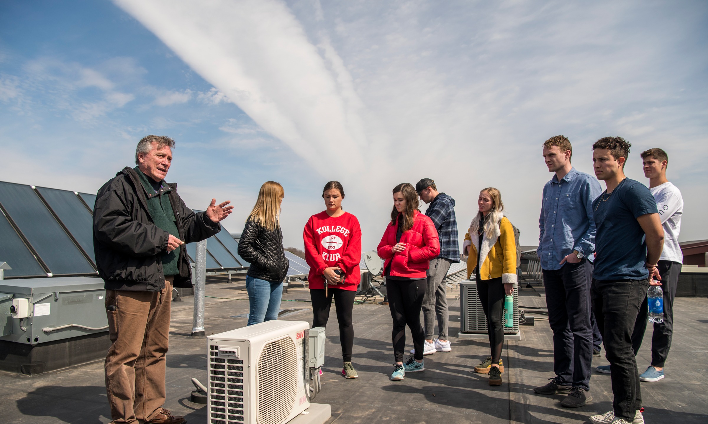 A teacher and eight students talking outside