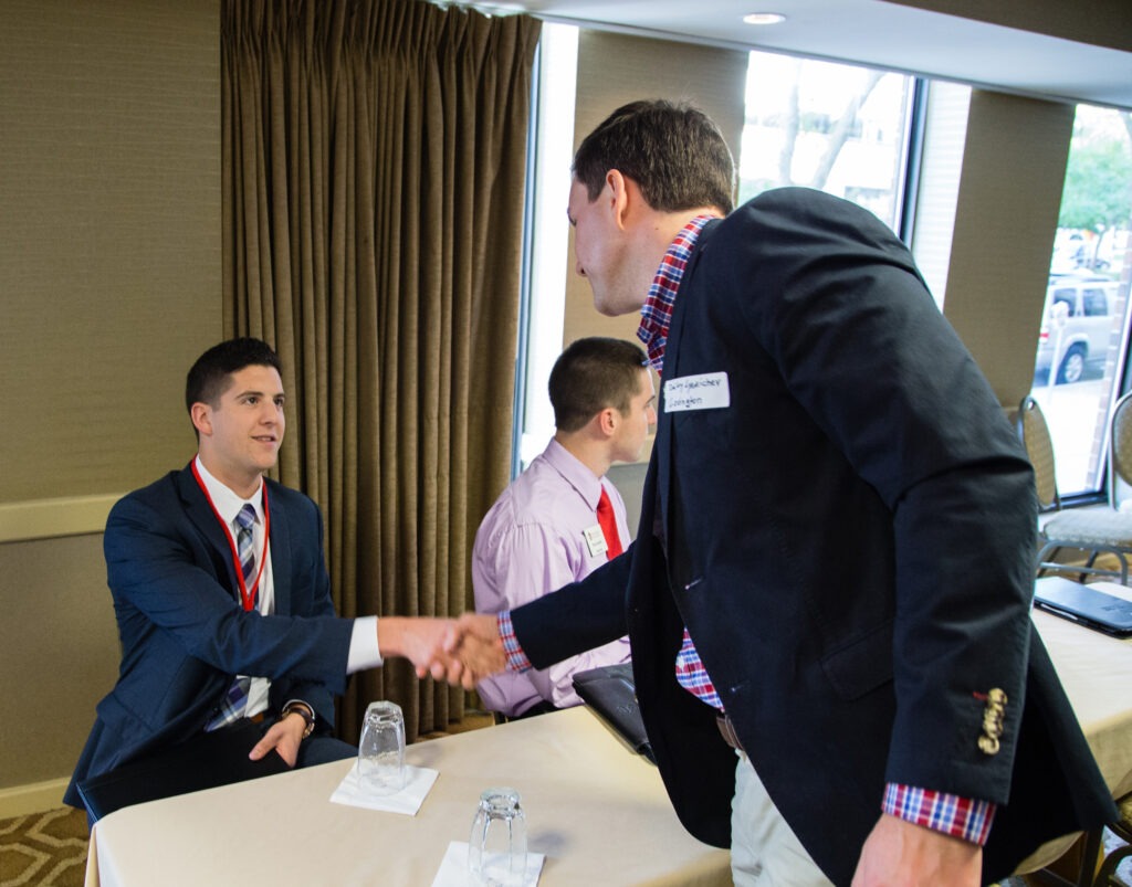 people shaking hands at networking event