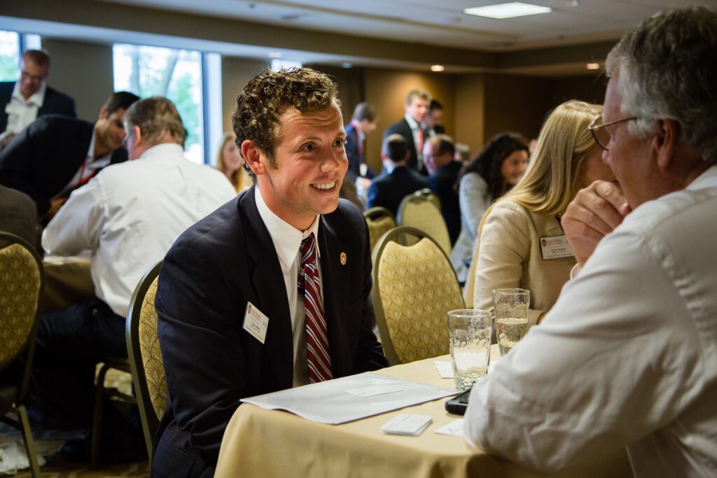 People networking at tables of two