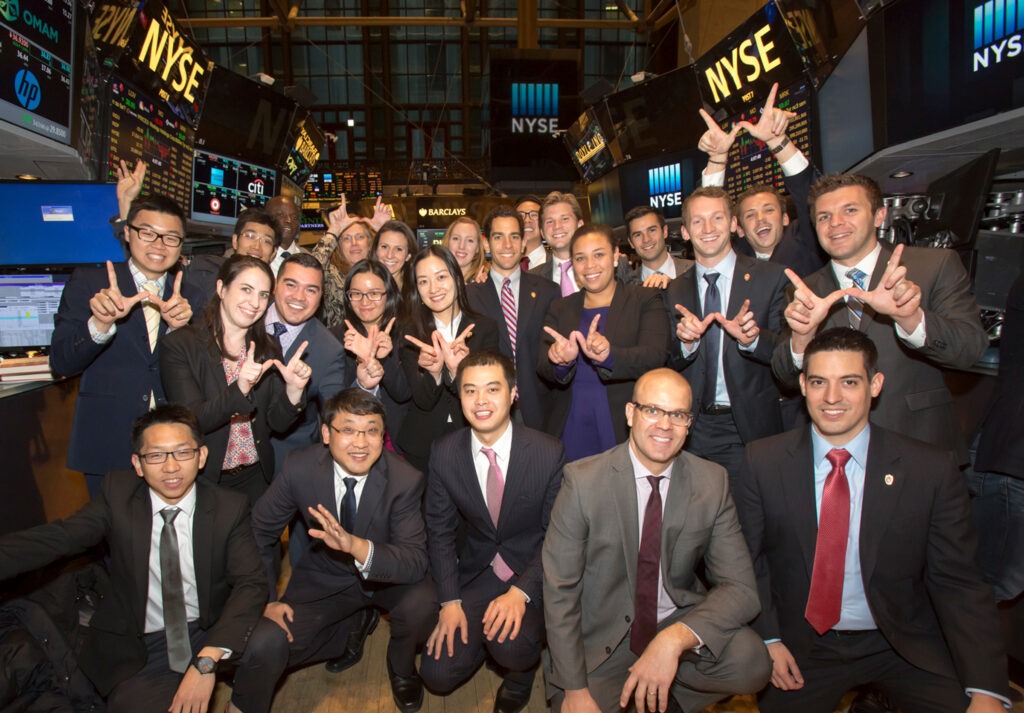 group of students posing in front of stock exchange