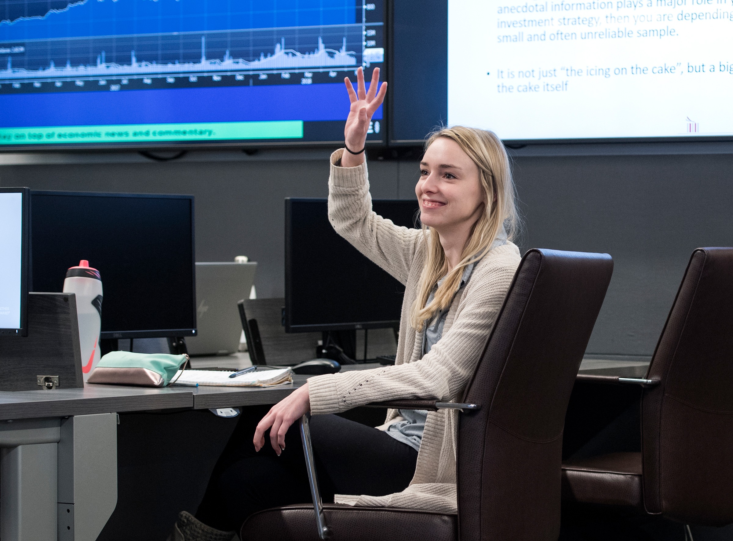 student raising hand in learning commons