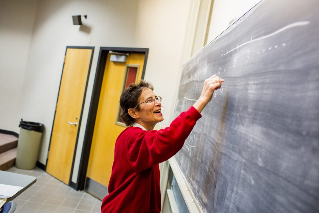 Professor Margie writing on a chalkboard