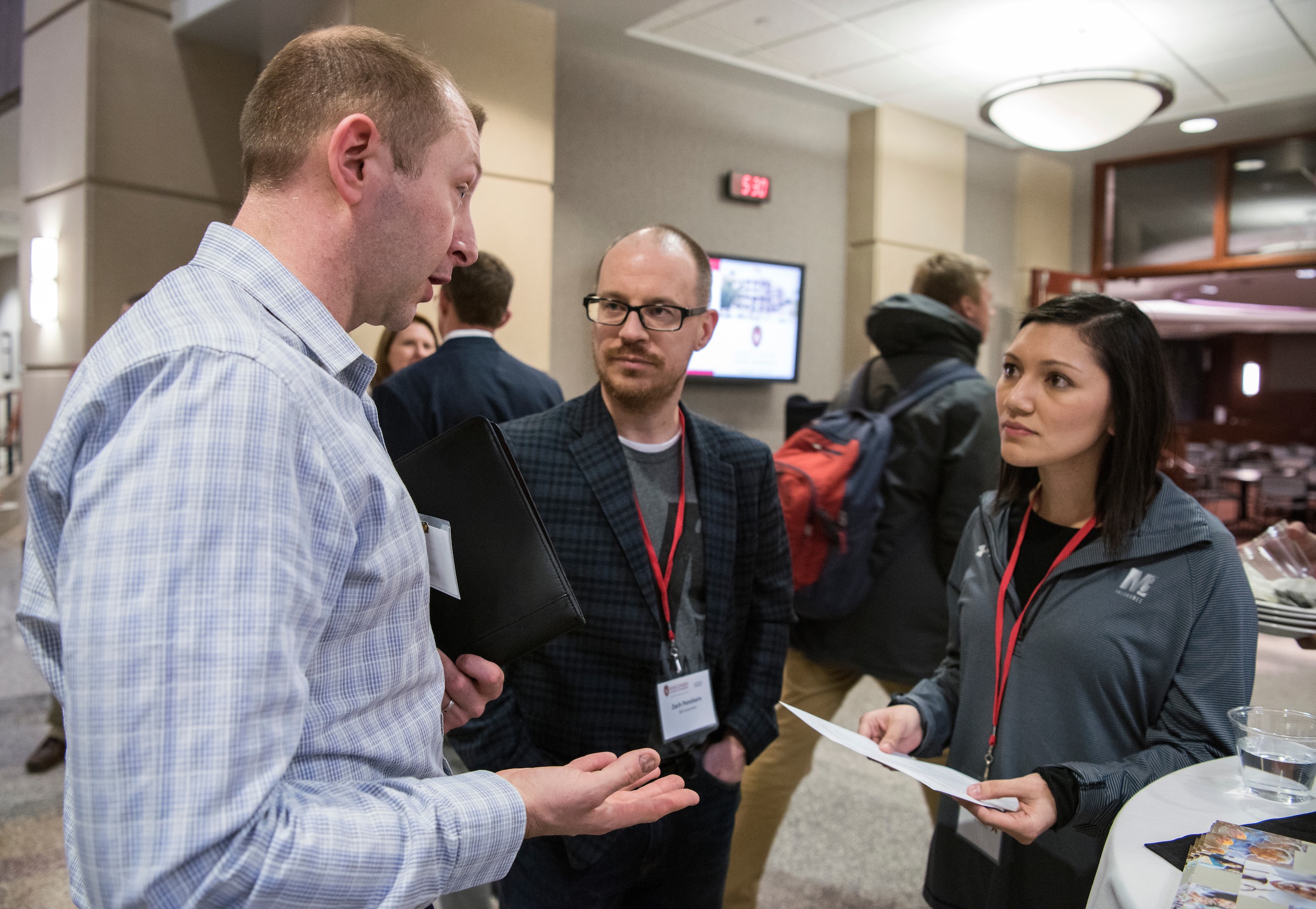 Two men and a woman networking at MBA Corporate Connections event