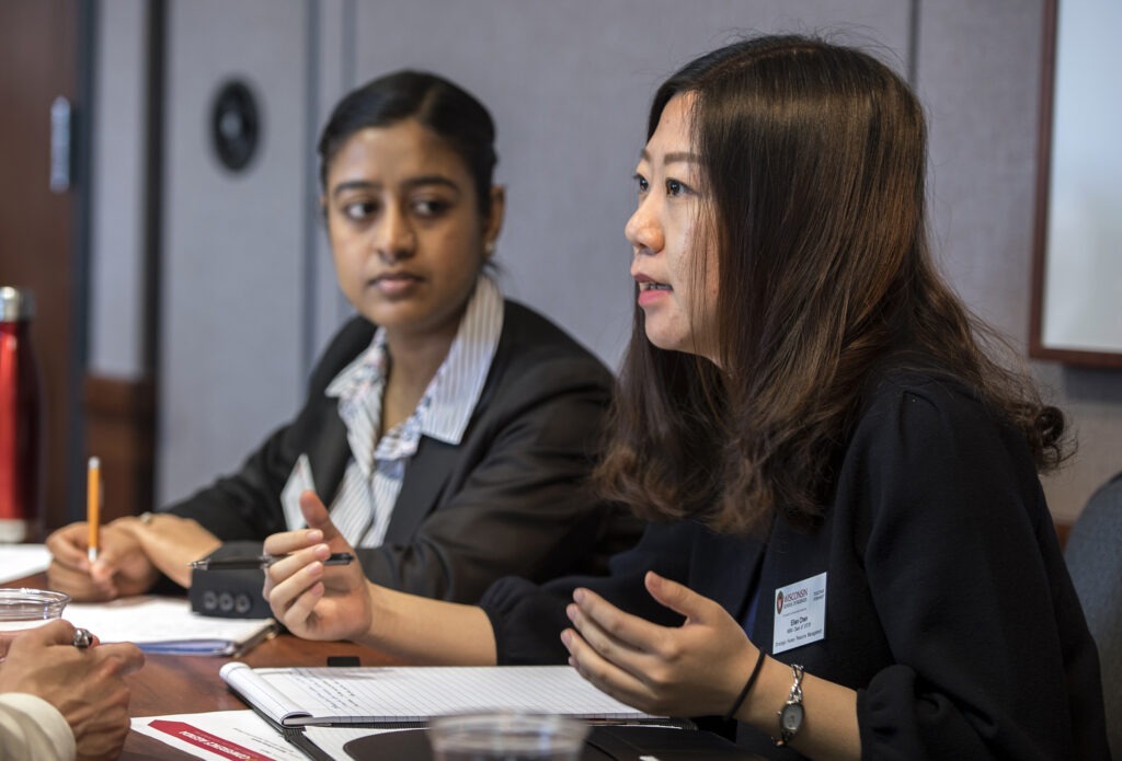 Two MBA students networking with members at the table at HR Summit Conference