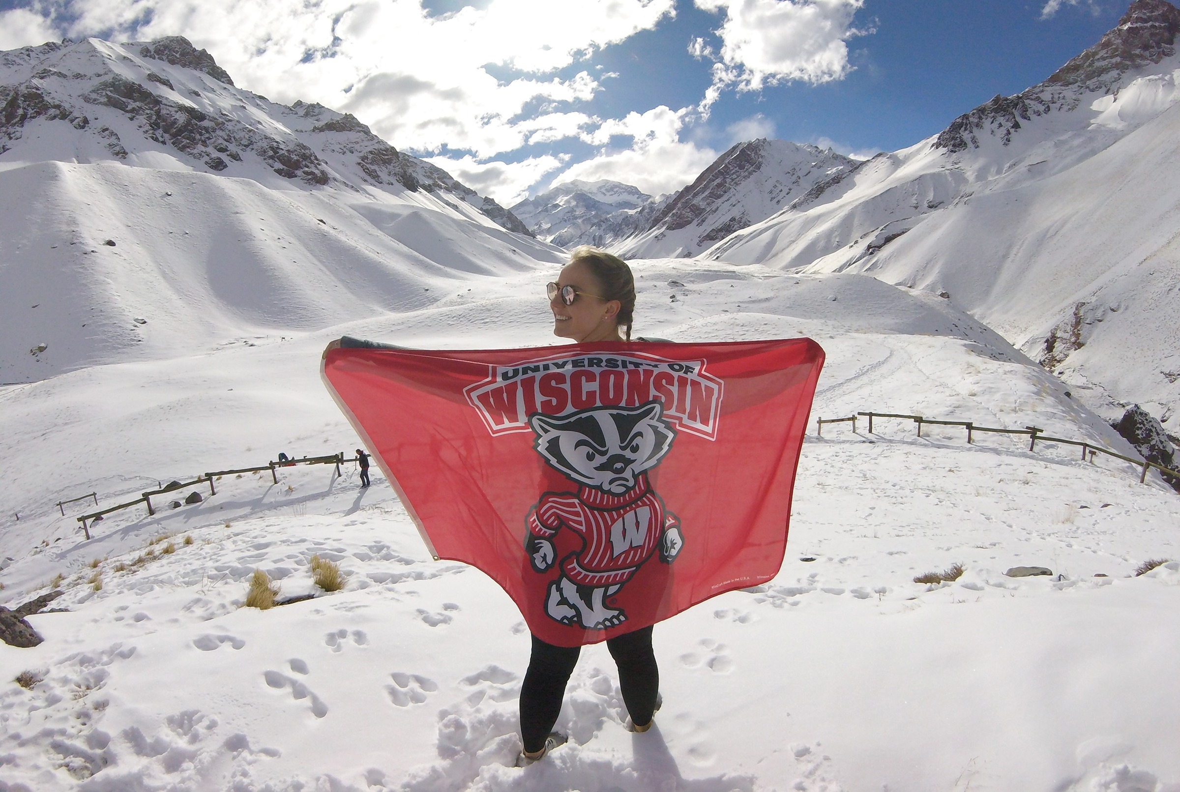 student displaying badger flag in snowy mountains