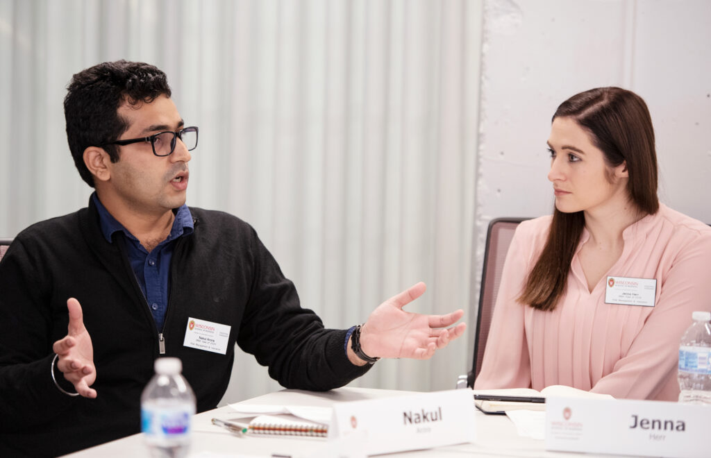 A man and a woman sitting at a table with the man talking to her