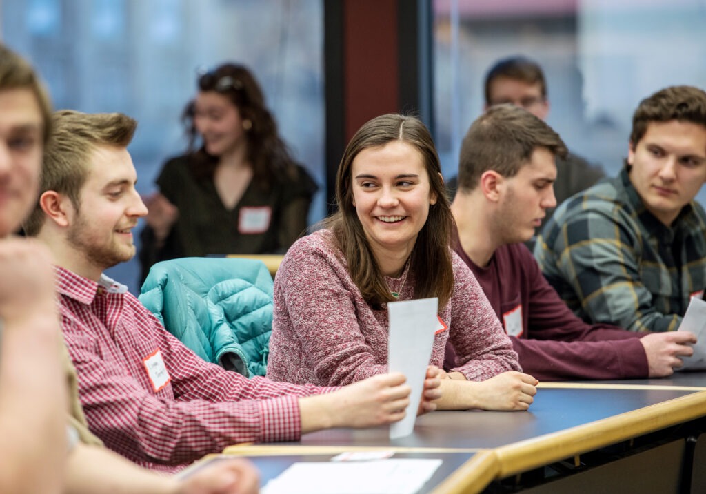 Students sitting at desk laughing and talking with each other