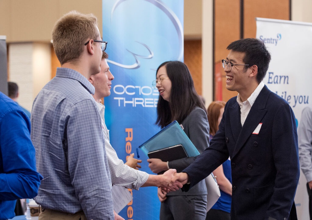 Two men shaking hands at the Risk and Insurance career fair