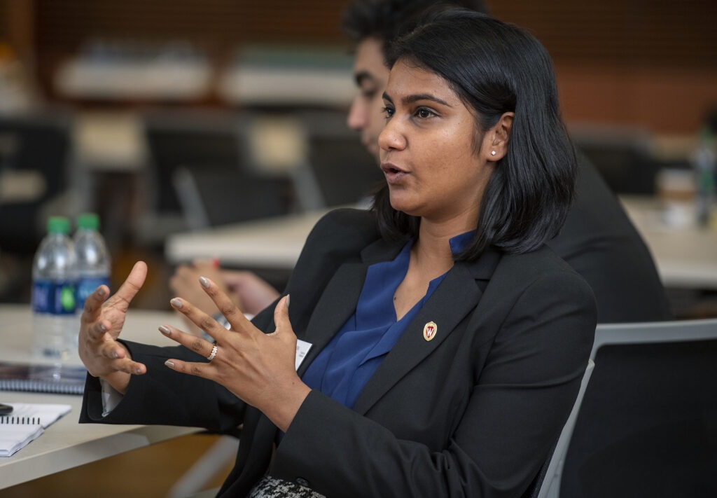 A woman sitting at a table talking with people