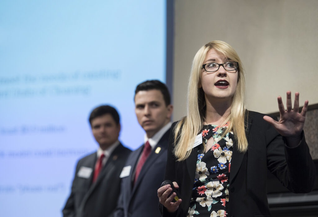 One woman and two men giving a presentation