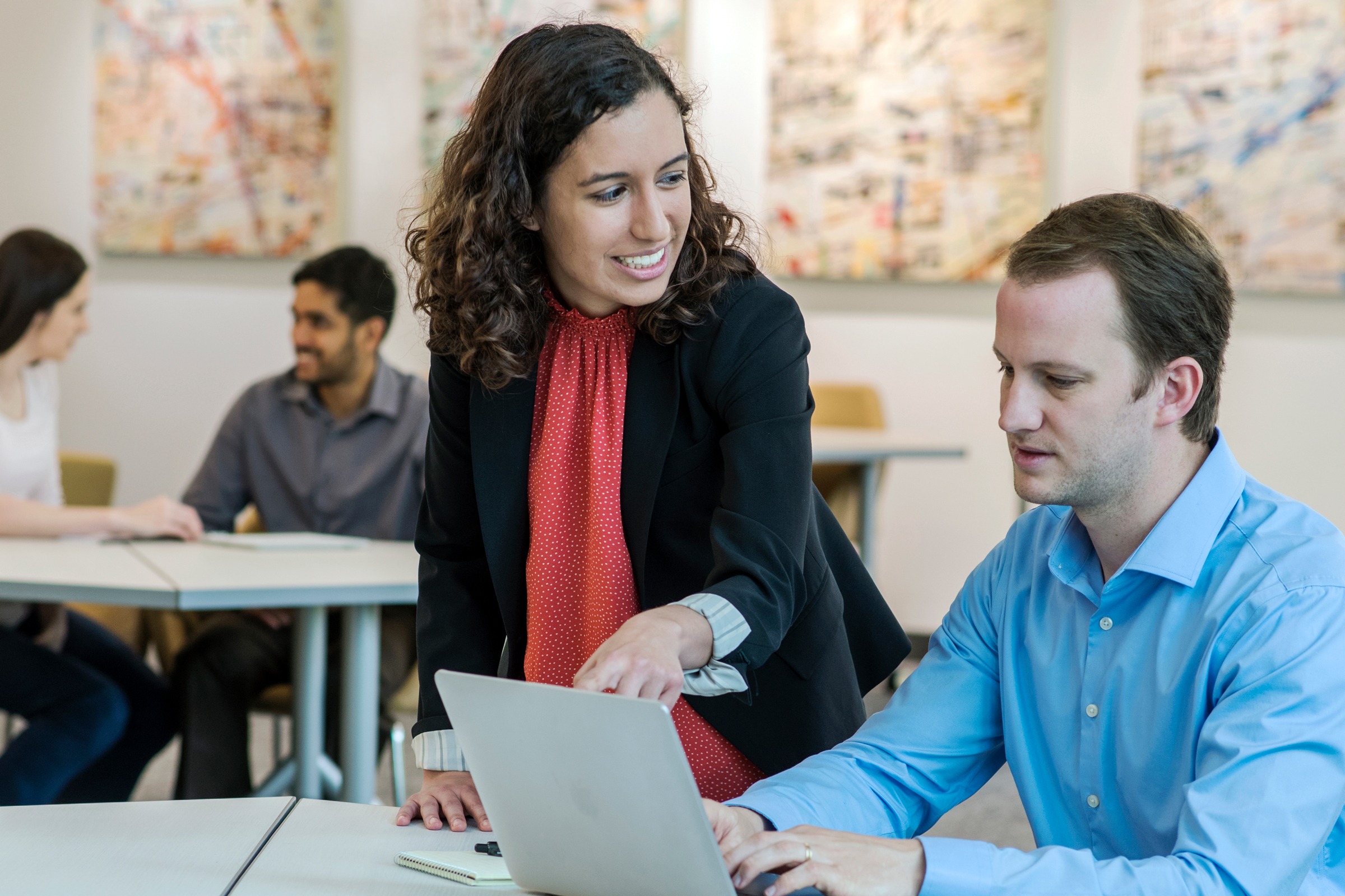 Two students collaborating over laptop