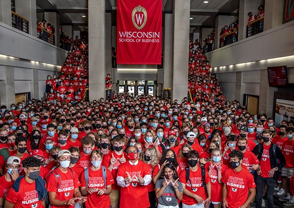 Dean Sambamurthy and new students making a W sign with their fingers