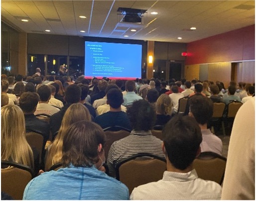 A group of people watching a presentation on a large screen